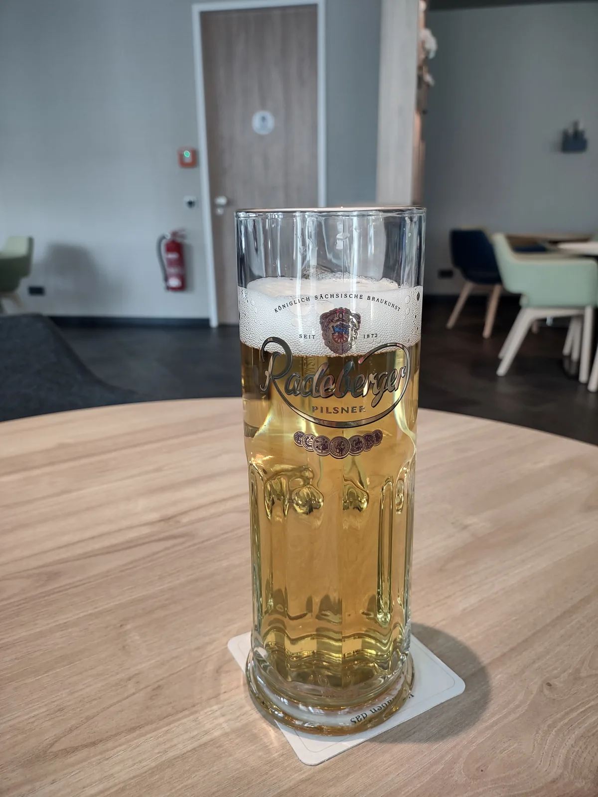 A cerveja Radeberger Pilsner é produzida pela cervejaria real saxônia Radeberg, fundada em 1872 na cidade de Radeberg, Alemanha. Esta é uma pilsner clássica alemã com um perfil aromático de lúpulo equilibrado, sabor limpo e refrescante característico do estilo. A cerveja apresenta uma cor dourada clara, espuma branca abundante e é conhecida por sua qualidade consistente e tradição cervejeira saxônica. Nota no Untappd: 3.71/5.